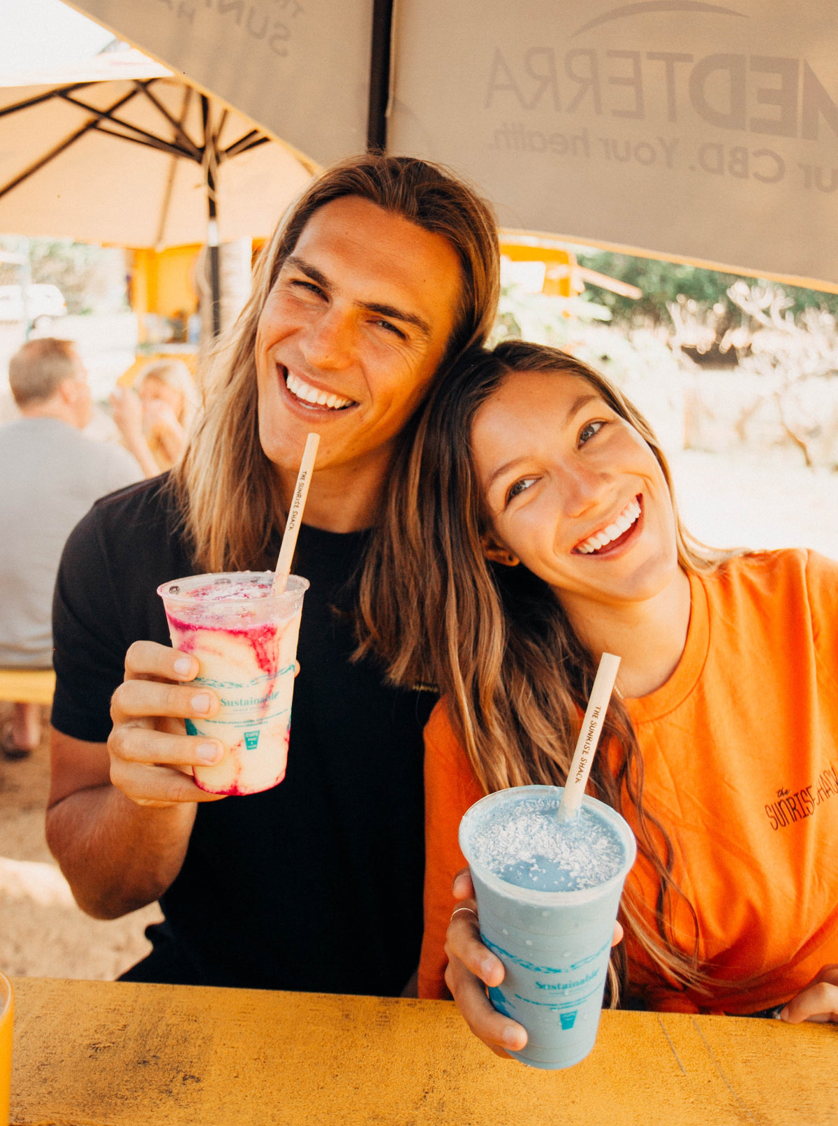smiling couple drinking with bamboo straws
