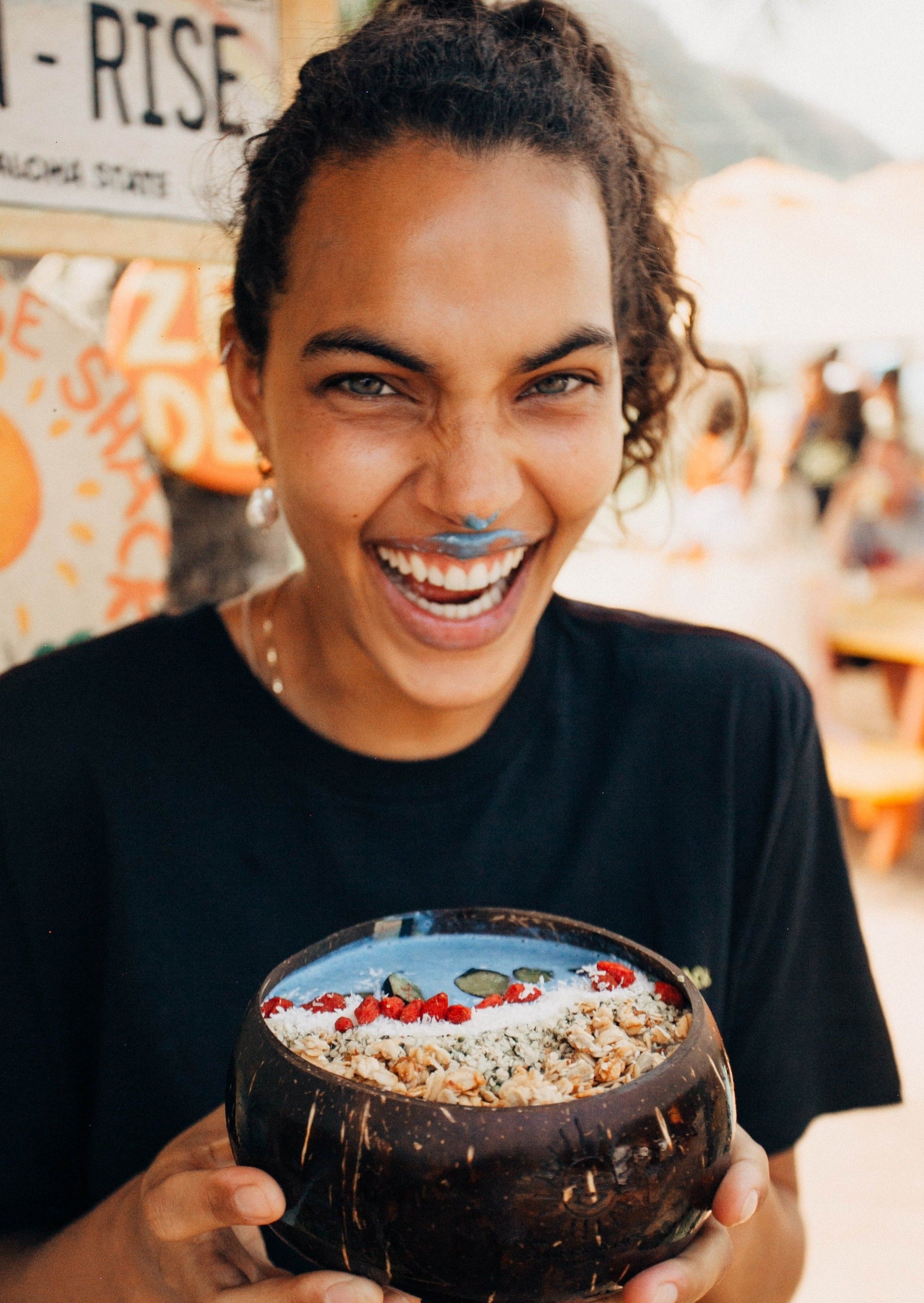 smiling woman holding coconut bowl