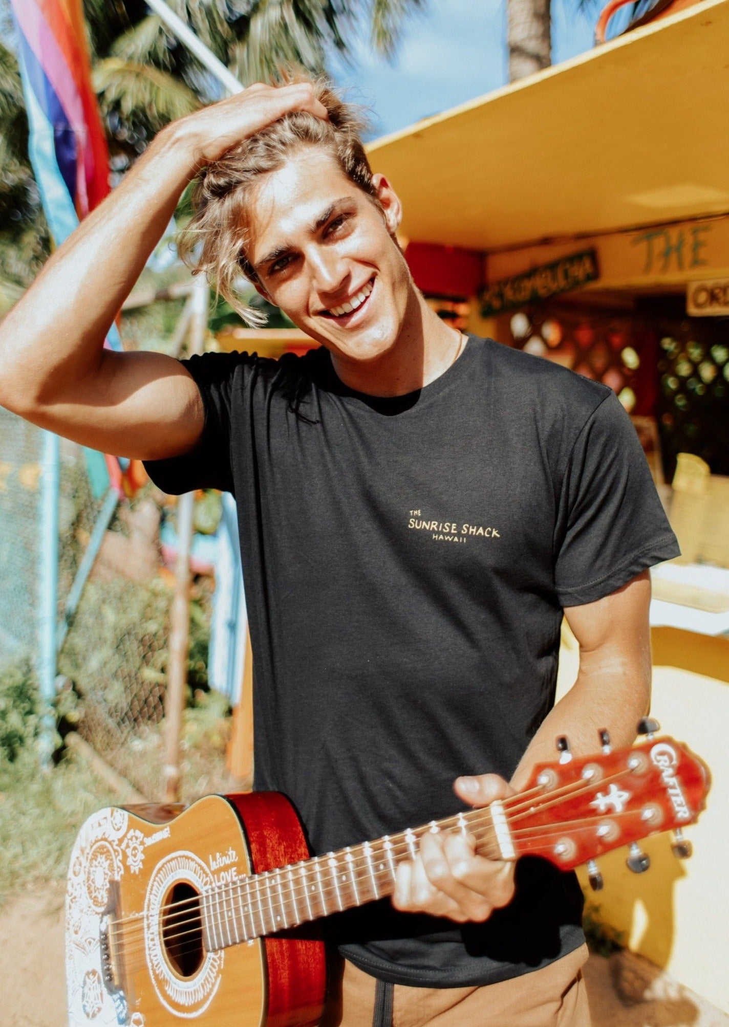 A man in a black tee shirt featuring The Sunrise Shack logo